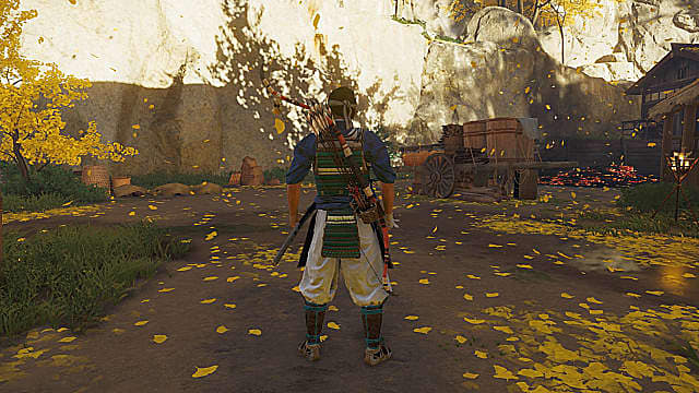Jin Sakai standing with the halfbow on his back in an open area surrounded by yellow trees.