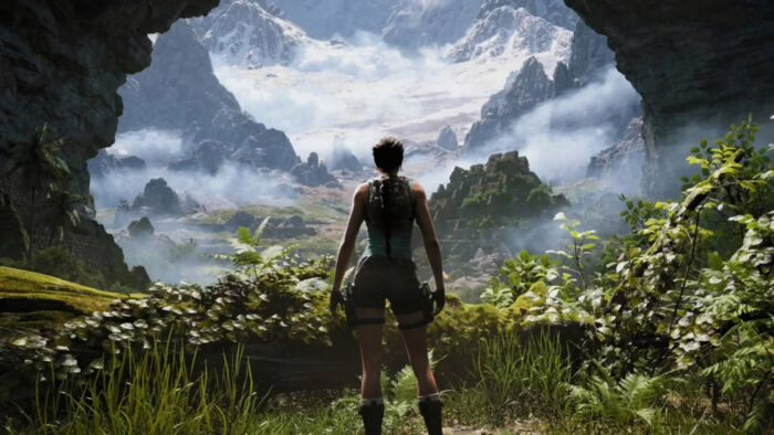 Lara Croft de pie en una cueva mirando un paisaje montañoso