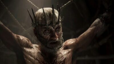 Personaje con corona de espinas en ambiente oscuro y tenebroso