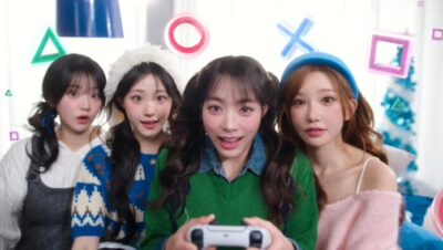 Cuatro mujeres jóvenes jugando con un mando de PS5 en un entorno festivo